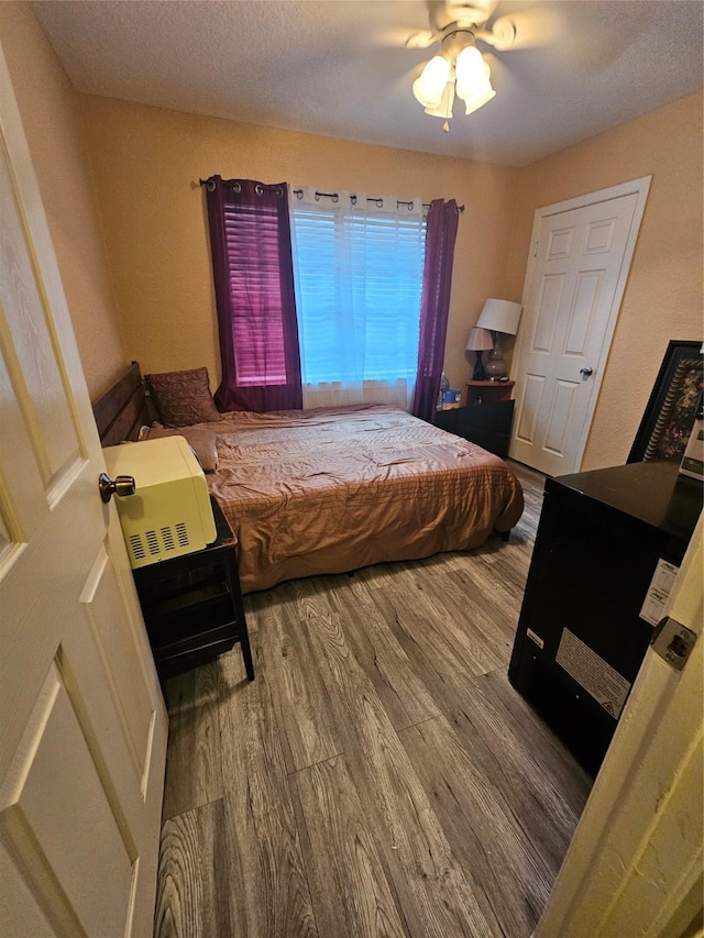 bedroom with ceiling fan and wood-type flooring