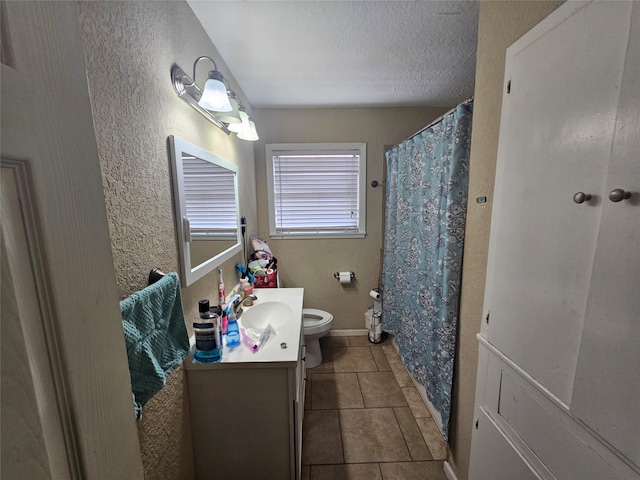 bathroom with tile patterned floors, vanity, toilet, and a textured ceiling