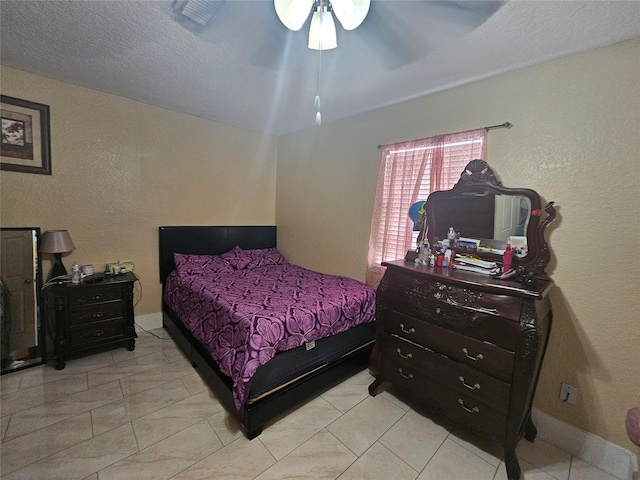 bedroom with ceiling fan and a textured ceiling