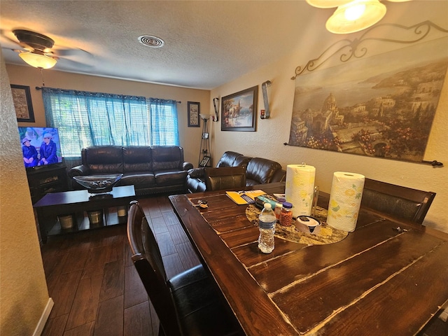 dining space with dark hardwood / wood-style floors, ceiling fan, and a textured ceiling