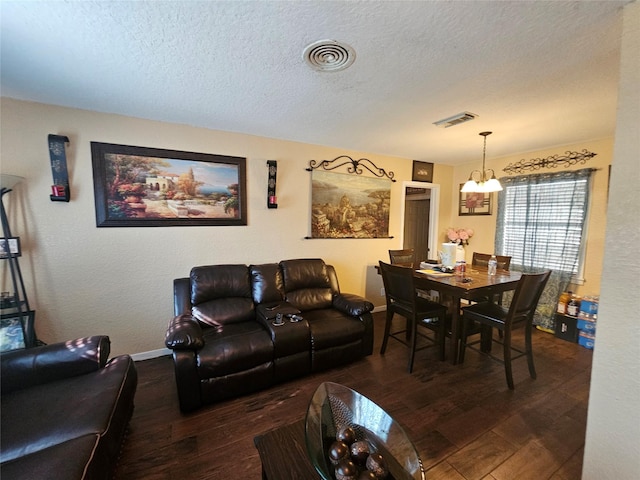 living room featuring hardwood / wood-style floors, a chandelier, and a textured ceiling