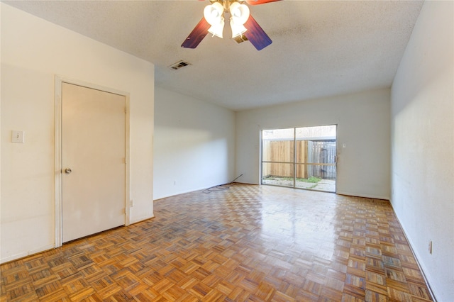 unfurnished room with dark parquet flooring, a textured ceiling, and ceiling fan