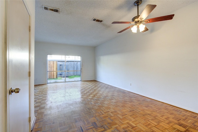 spare room featuring ceiling fan, parquet floors, and a textured ceiling