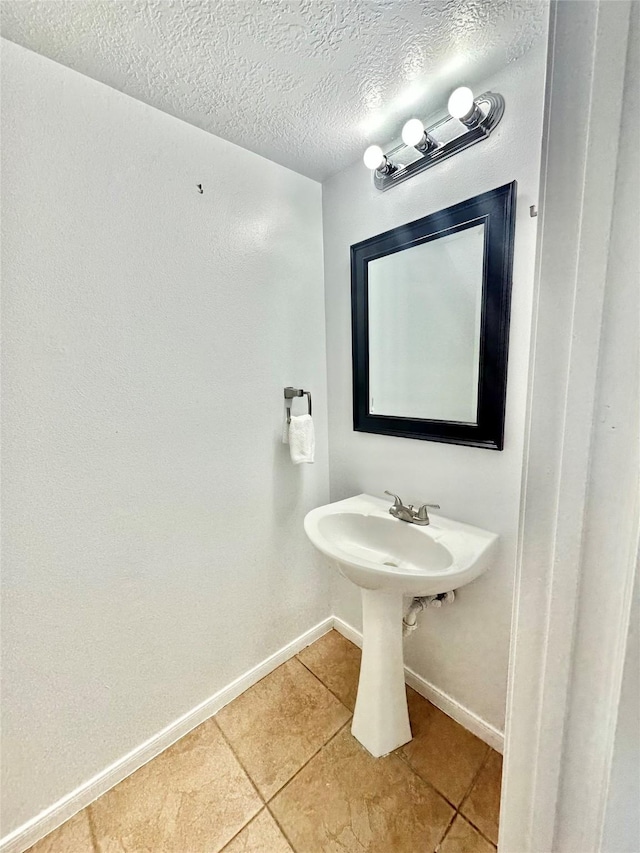 bathroom featuring tile patterned floors and a textured ceiling