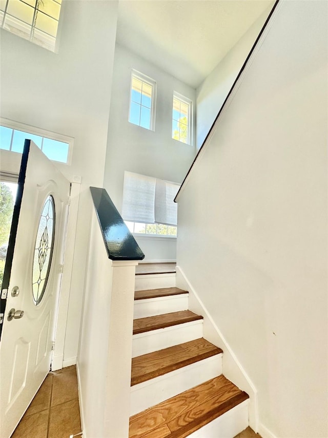 tiled foyer featuring a towering ceiling