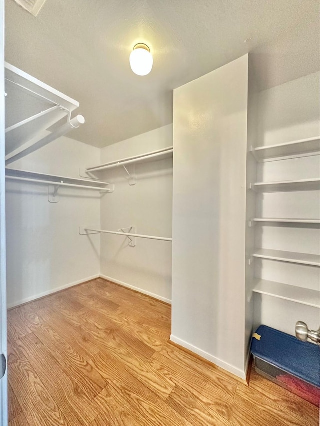 walk in closet with hardwood / wood-style floors