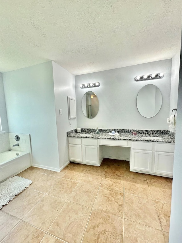 bathroom featuring a washtub, a textured ceiling, vanity, and tile patterned flooring