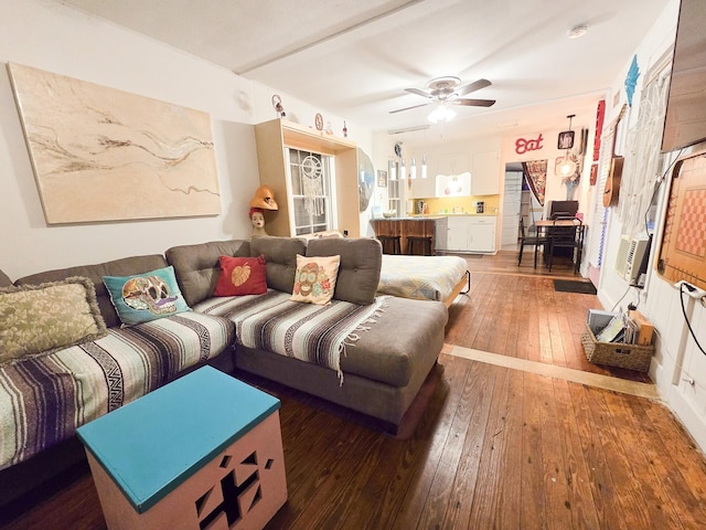 living room with ceiling fan and dark wood-type flooring