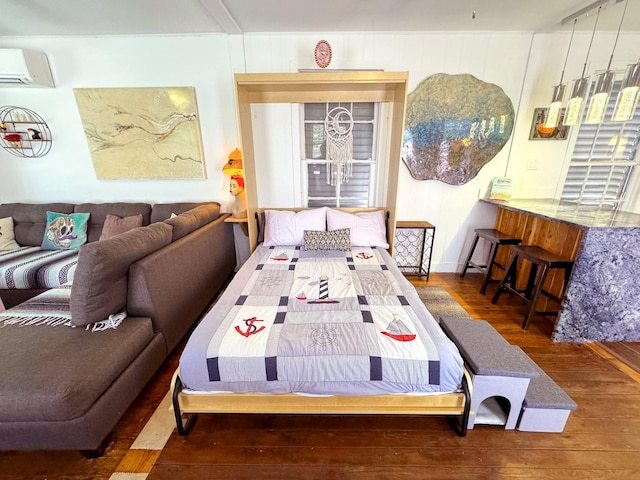 bedroom with a wall mounted AC and dark wood-type flooring