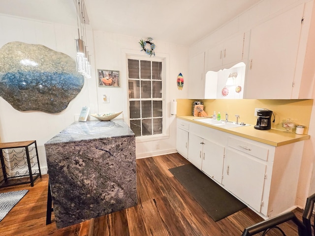 kitchen with white cabinets, sink, and dark wood-type flooring