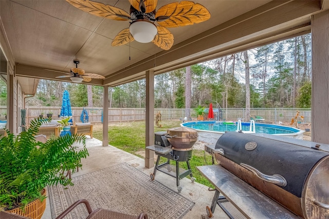 view of patio / terrace with ceiling fan, a grill, and a fenced in pool