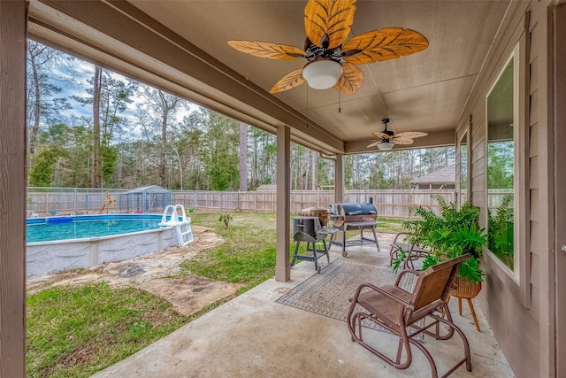 view of patio / terrace featuring ceiling fan and a fenced in pool