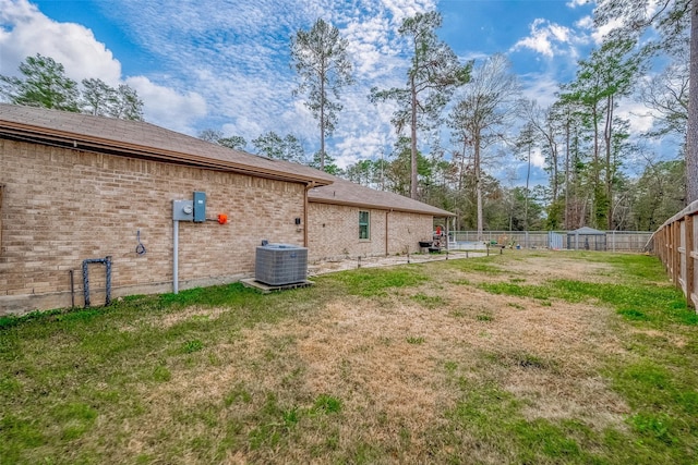 exterior space with central air condition unit and a yard