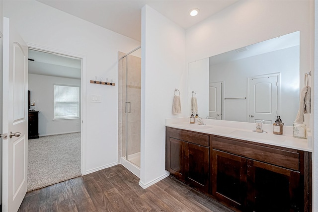 bathroom featuring wood-type flooring, an enclosed shower, and vanity