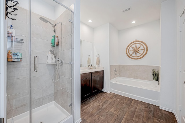 bathroom featuring wood-type flooring, vanity, and separate shower and tub