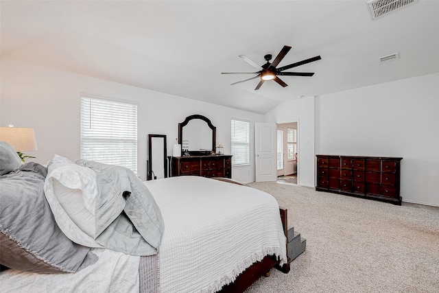 carpeted bedroom with ceiling fan and vaulted ceiling