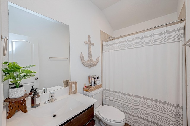 bathroom with toilet, vanity, and lofted ceiling