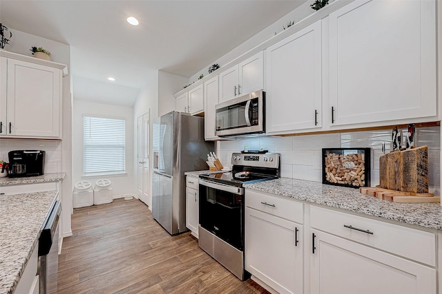 kitchen featuring white cabinets, backsplash, and appliances with stainless steel finishes