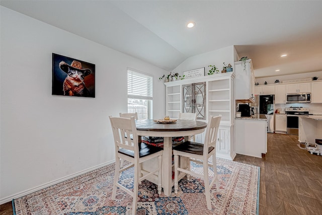 dining space featuring vaulted ceiling and hardwood / wood-style floors