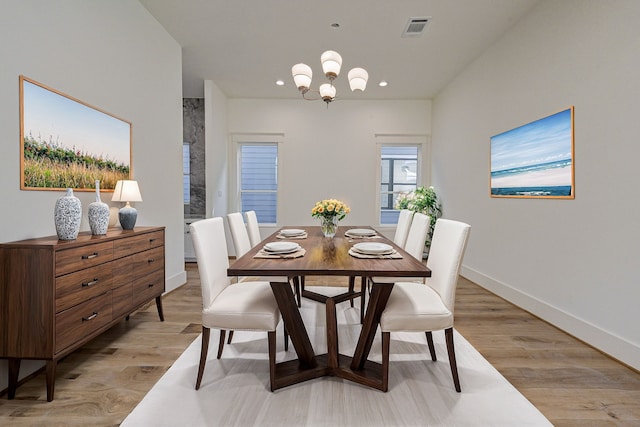 dining area with a chandelier and light hardwood / wood-style flooring