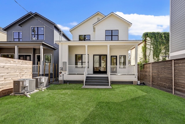 back of house with a porch, central air condition unit, and a yard