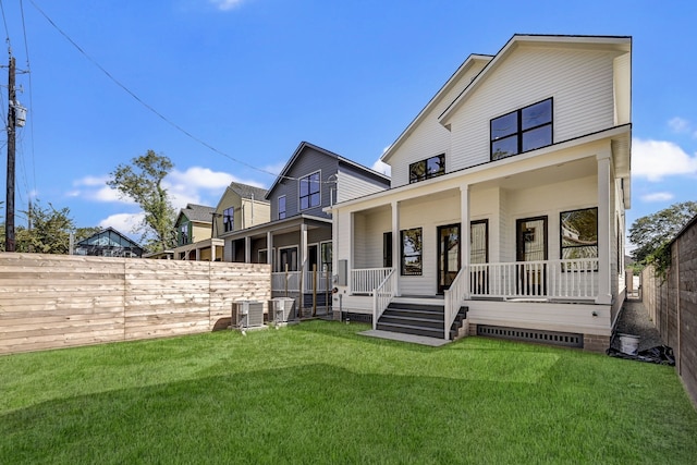 rear view of house with a porch, cooling unit, and a lawn