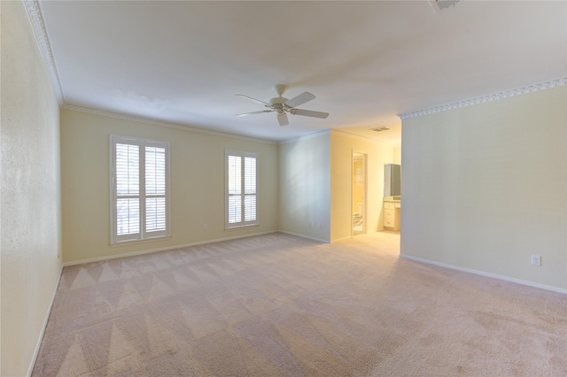 spare room featuring ornamental molding, ceiling fan, and light colored carpet