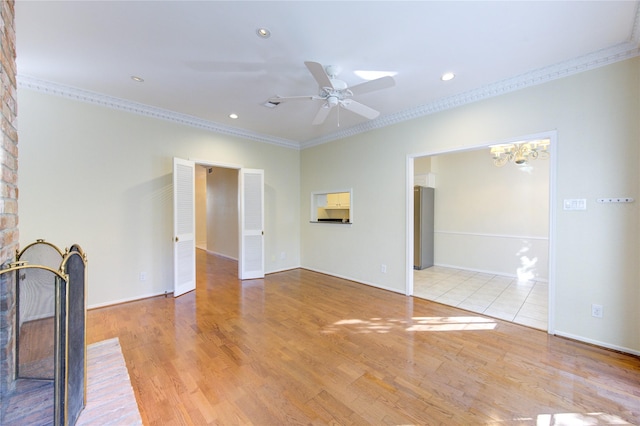 unfurnished living room with ceiling fan with notable chandelier, ornamental molding, and light hardwood / wood-style floors