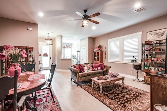 tiled living room featuring a wealth of natural light, ceiling fan, and sink