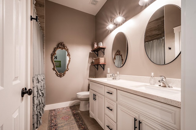 bathroom featuring tile patterned flooring, vanity, and toilet