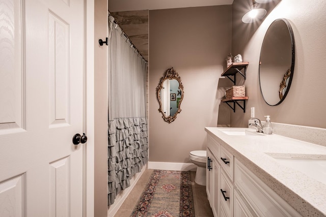 bathroom with tile patterned floors, curtained shower, vanity, and toilet