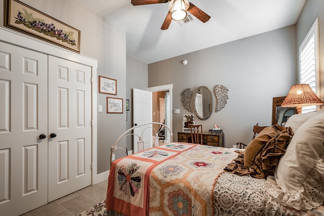 bedroom featuring ceiling fan, light tile patterned flooring, and a closet