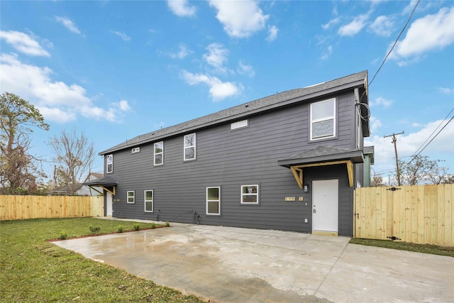 rear view of house with a yard and a patio