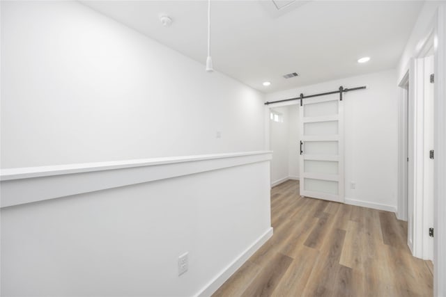 walk in closet featuring hardwood / wood-style floors and a barn door