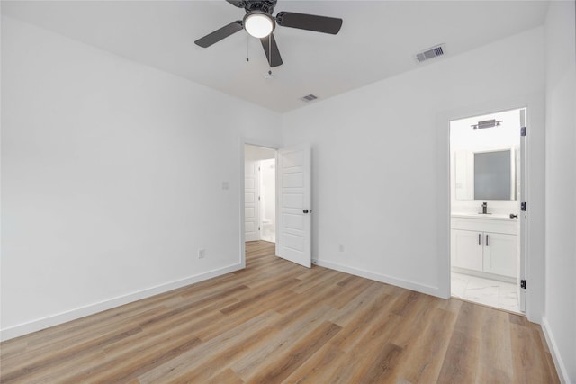 unfurnished bedroom featuring ceiling fan, sink, connected bathroom, and light hardwood / wood-style flooring