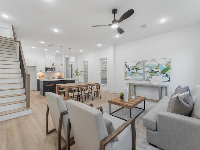 living room featuring ceiling fan and light wood-type flooring