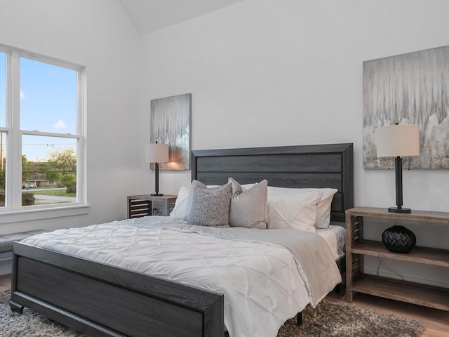 bedroom with hardwood / wood-style flooring and lofted ceiling