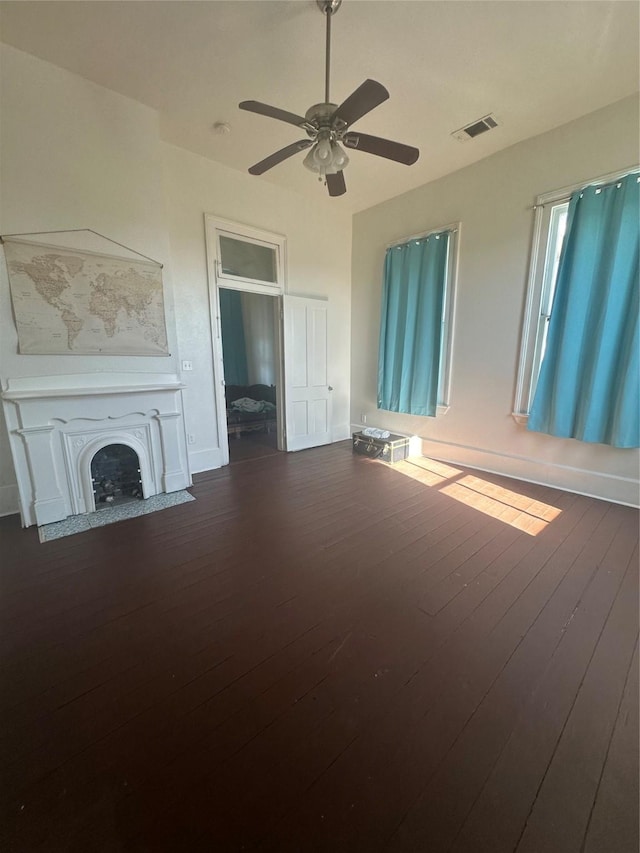 unfurnished living room featuring dark hardwood / wood-style floors and ceiling fan