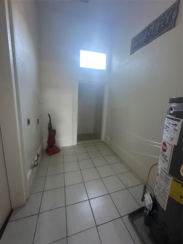 interior space with electric dryer hookup and light tile patterned floors