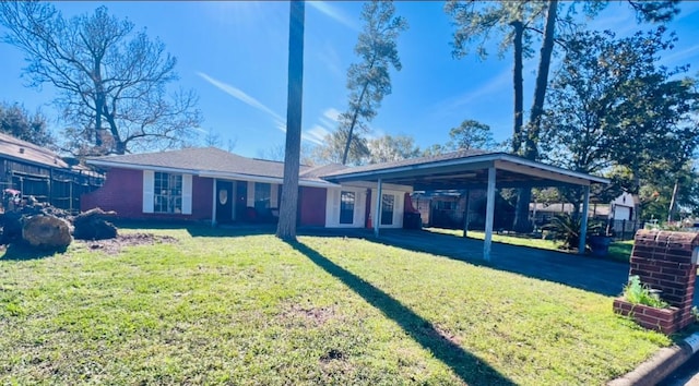 rear view of property with a carport and a yard