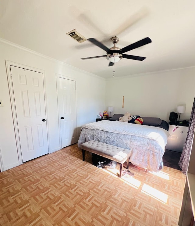 bedroom featuring visible vents, ornamental molding, and a ceiling fan