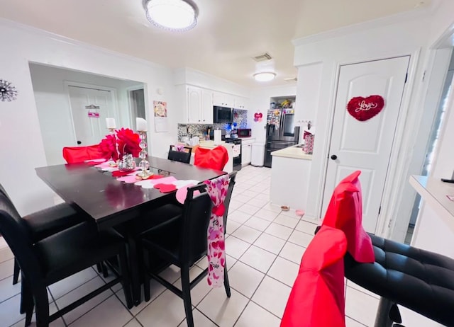 dining area featuring ornamental molding and light tile patterned flooring