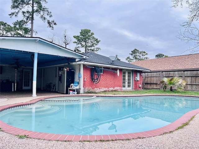 view of swimming pool featuring fence, a fenced in pool, and a ceiling fan