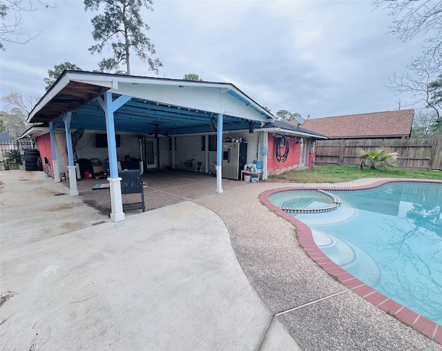 view of swimming pool featuring a patio area, a fenced backyard, and a pool with connected hot tub