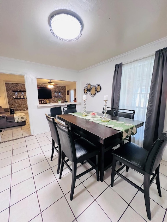 dining area featuring a ceiling fan, crown molding, and light tile patterned flooring