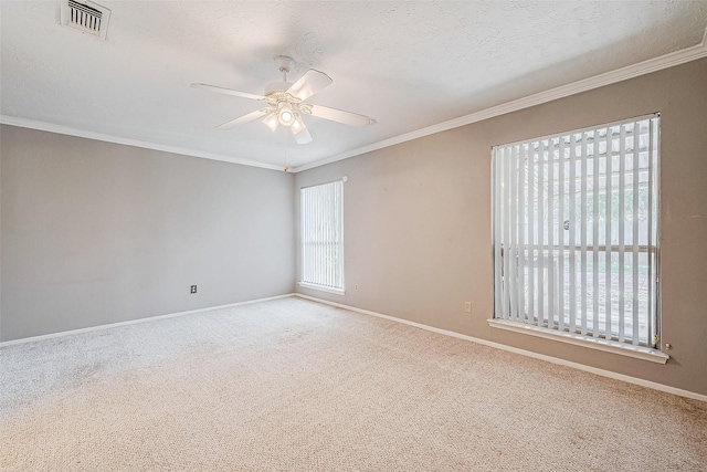 empty room featuring ceiling fan, a textured ceiling, carpet, and crown molding