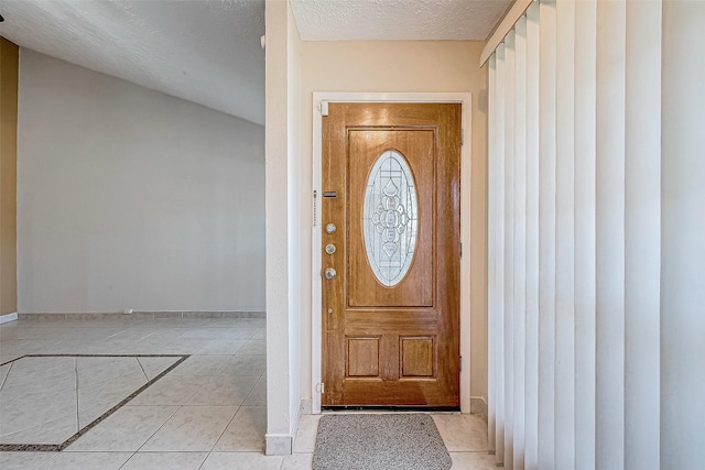 entryway with a textured ceiling and light tile patterned floors