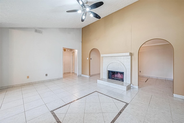 unfurnished living room featuring light tile patterned floors, baseboards, a textured ceiling, and a fireplace