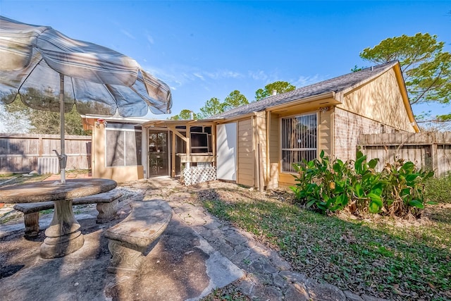 back of house with fence and a sunroom