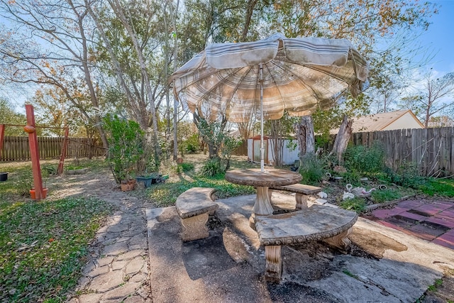 view of yard featuring an outbuilding, a fenced backyard, and a patio area